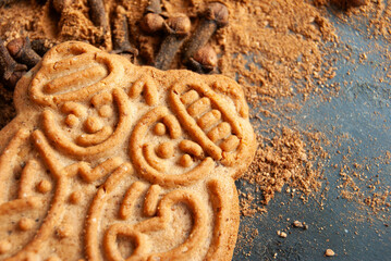 Festive cinnamon cookies with cloves and cinnamon arranged on a deep blue backdrop, capturing holiday warmth.