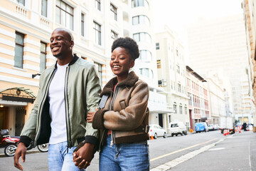 Fototapeta premium Happy Couple Strolling Hand in Hand Through a City Street on a Sunny Day, Enjoying Quality Time Together