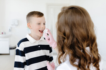 An allergist uses a spray for a patient to treat allergies. Allergen-specific immunotherapy