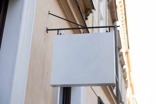Street storefront shop, cafe, restaurant mounted signboard mock up design template. Blank white store sign design mockup.