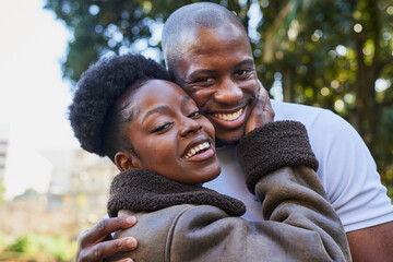 Happy Couple Embracing Outdoors in a City Park While Smiling Brightly