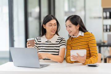 Two Asian female students wearing headphones chatting in an online chat meeting using a laptop. Female college students learn remotely