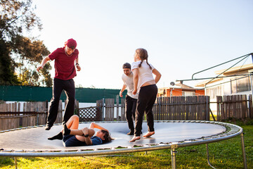First Nations Australian Kids playing crack the egg on trampoline in backyard