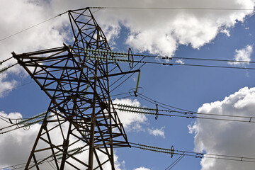 High voltage power line on blue sky background in Sunny day. wires, problems with electricity, power transmission. power line construction of cable supports and insulators. blackout, crisis