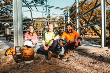 Construction workers sitting on the cemented floor.