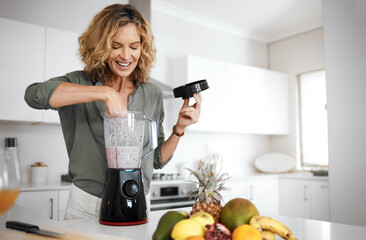 Mature woman, blender and smoothie in kitchen with smile for nutrition, wellness and meal prep in...
