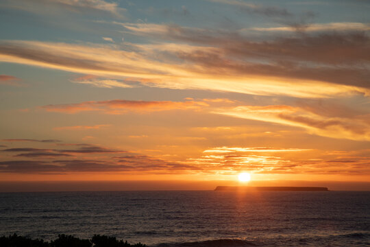 Sun setting behind Lady Julia Percy Island viewed across the water from The Crags on The Great Ocean