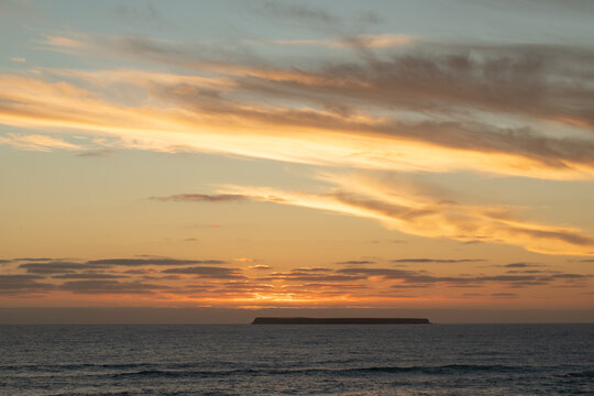 Sun setting behind Lady Julia Percy Island viewed across the water from The Crags