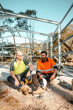 Construction workers sitting on the cemented floor.