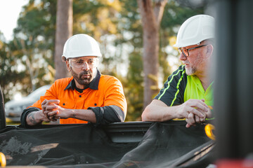 Two builders standing next to ute wearing hardhats