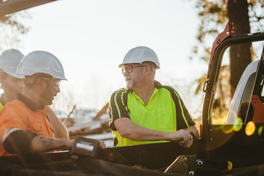 Three builders standing next to ute on worksite
