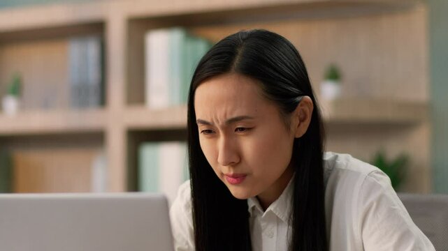 Confused grumpy Asian Japanese businesswoman female girl Chinese Korean business woman worker online work laptop pc computer problem shock bad failure mistake negative shaking head no in office room