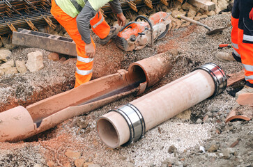 Builders replacing damaged underground drainage pipe