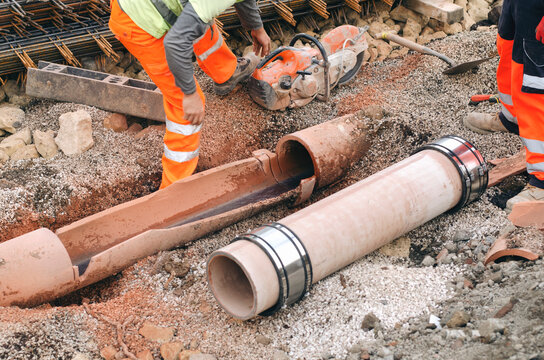 Builders replacing damaged underground drainage pipe