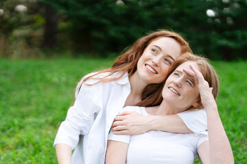 Fototapeta premium Two women enjoying a sunny day in the park while spending quality time together and sharing laughter