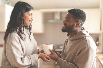 Couple enjoying a warm moment together while sharing a cup of coffee in their cozy kitchen during the morning