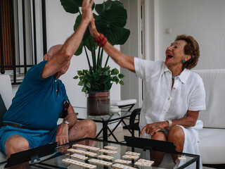 Marriage octogenarian play animatedly to a board game consisting of making combinations of numbers