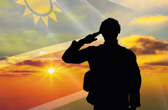 Silhouette of a soldier with a background of the Namibia flag and a sunset or sunrise. Concept of national holidays. Commemoration Day.