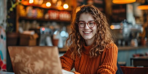 Obraz premium Portrait of a person smiling while working on a laptop in a coffee shop, focused on research, networking, and freelance projects with a sense of happiness and technology