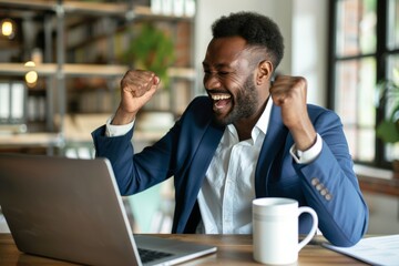 Excited man at laptop in office celebrates success and good news of approved financial loan for ecommerce startup and sales achievements