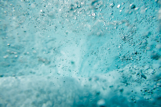 Close-up of turbulent underwater wave with bubbles