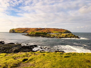 Landscape view over the Irish Sea and Sound to the Calf of Man from the south of the Isle of Man. Rocky cliffs, green grass and blue seas. © Selena