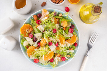 Salad bowl with lettuce, tangerines, nuts and cranberry