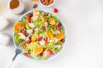 Salad bowl with lettuce, tangerines, nuts and cranberry