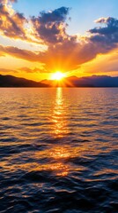 Obraz premium Stunning sunset over calm water, vibrant colors reflecting on surface.