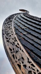 Close-up of a Viking ship replica in Tønsberg, Norway, showcasing intricate wood carvings and...