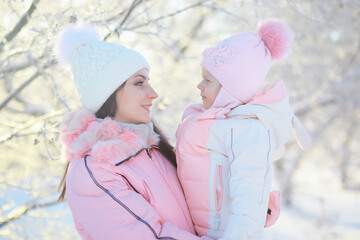 Family with children play snowy winter games in the park. Winter holidays and family vacation. Winter walk on the street on a sunny frosty day.