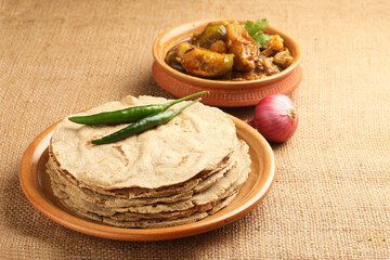 Jowar Roti or Jowar Bhakri with brinjal curry ,  a staple food in the Indian states of Maharashtra, Gujarat, and Karnataka. Sorghum is a versatile and nutrient-rich grain.