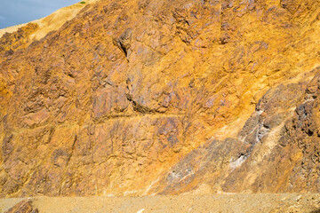 Orange, rusty, yellow rock formations on a mountain side in Denali National Park, Alaska