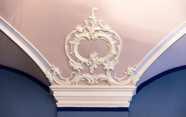 White bas-relief decoration details over blue pink ceiling and wall