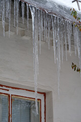 Large long icicles hang from roof of house