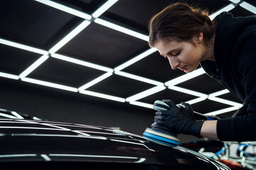 Woman Polishing Car in Professional Auto Workshop