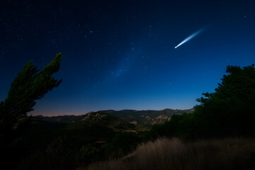 Fototapeta premium A dramatic shot of a comet passing through the night sky, illustrating the beauty of astronomical phenomena. A comet in space.