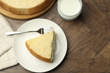 Piece of delicious sponge cake served on wooden table, flat lay. Space for text