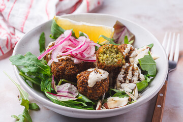 Falafel salad with tahini, red pickled onions and nuts.
