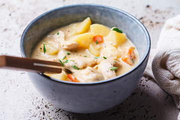 Chicken stew in creamy sauce with potatoes and carrots. Comfort food concept.