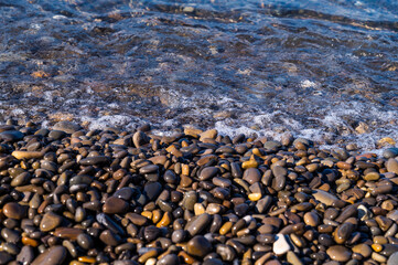 Water sea beach. Wave ocean blue. Stone texture reflection sun. Surface coast pebbles. 
