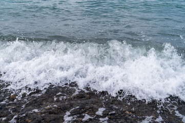 Water sea beach. Wave ocean blue. Stone texture reflection sun. Surface coast pebbles. 