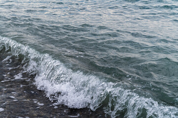 Water sea beach. Wave ocean blue. Stone texture reflection sun. Surface coast pebbles. 