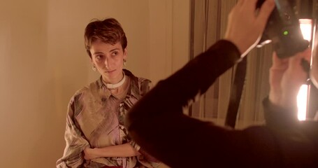 Shooting at home. A skilled photographer captures a model elegantly posed in a stylish, softlit indoor setup, showcasing beauty