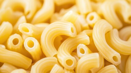 Close-up of yellow elbow macaroni pasta arranged neatly, showcasing its curved shape and texture.