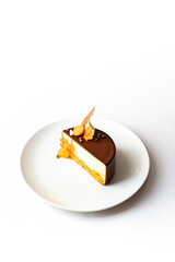 Small chocolate bento cake with decorations on white plate isolated on white background