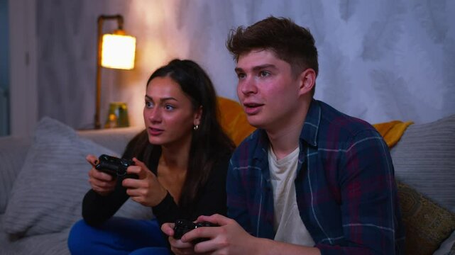 Cute couple playing video games win and celebrate together and high five emphatically