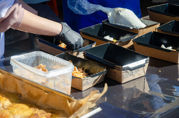 Close-up of prepared food placed in containers at an outdoor open kitchen