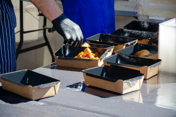 Close-up of prepared food placed in containers at an outdoor open kitchen