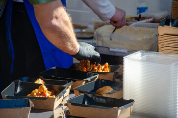 Close-up of prepared food placed in containers at an outdoor open kitchen